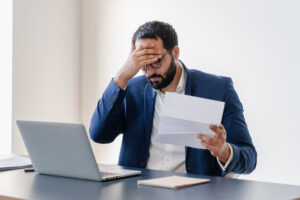 Sad Fatigued Stressed Businessman Holding Negative Audition Results, Reports, Bills - Vision Soluções Trabalhistas em Chapecó - SC
